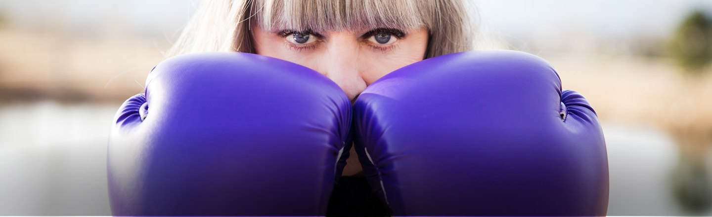 Jan Fisher Johnson with purple boxing gloves raised, ready to fight